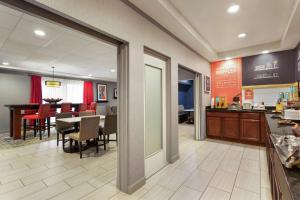 a dining room and kitchen with a table and chairs at Hampton Inn Kansas City Blue Springs in Blue Springs