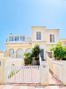 uma casa com um portão branco em frente em Casa Natura Sunset Beach em Gran Alacant