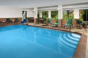una gran piscina con sillas y mesas en un hotel en Hampton Inn Kansas City The Legends, en Kansas City