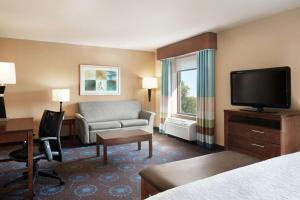 GraftonにあるHampton Inn & Suites Graftonのベッド、ソファ、テレビが備わるホテルルームです。
