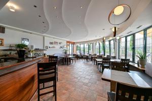 a restaurant with tables and chairs and windows at Villa Hresc M in Zadar