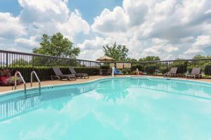 a large swimming pool with chairs and a fence at Hampton Inn Manassas in Manassas