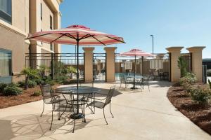 a patio with tables and chairs with umbrellas at Hampton Inn West Monroe in West Monroe