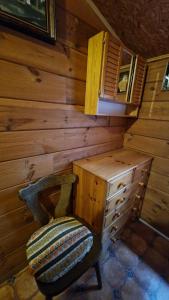 Cette chambre en bois comprend une chaise et une armoire en bois. dans l'établissement Przystań wodnica, à Ustka