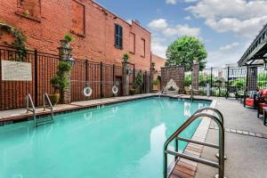 einem Pool vor einem Backsteingebäude in der Unterkunft Hampton Inn & Suites Mobile - Downtown Historic District in Mobile