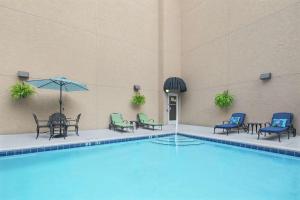 uma piscina com cadeiras e mesas e um guarda-sol em Hampton Inn Fairhope-Mobile Bay, AL em Fairhope