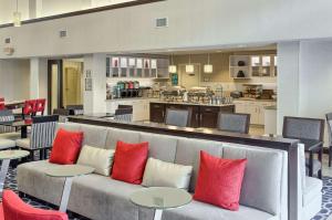 a living room with a couch and tables and a kitchen at Homewood Suites by Hilton Mobile in Mobile