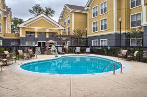 a swimming pool with patio furniture and a building at Homewood Suites by Hilton Mobile in Mobile