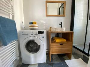a washing machine in a bathroom with a mirror at Appartement, Royan. Proche plage. in Royan