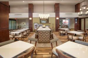 uma sala de jantar com mesas e cadeiras num restaurante em Hampton Inn & Suites Mobile Providence Park/Airport em Mobile