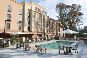 a hotel patio with tables and chairs and a pool at Hampton Inn & Suites Mobile Providence Park/Airport in Mobile