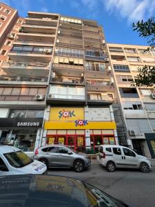 wysoki budynek z samochodami zaparkowanymi przed nim w obiekcie Lüks manzaralı daire w mieście Burunabat