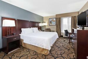 a hotel room with a bed and a television at Hampton Inn Monroe in Monroe