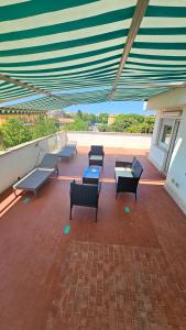 un patio con panche e tavoli su un edificio di Attico Sea and Sunset a Lido di Ostia