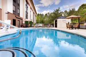 una grande piscina blu di fronte a un edificio di Hampton Inn Morganton a Morganton