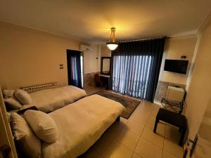 a hotel room with two beds and a tv at Salome Hotel in Madaba