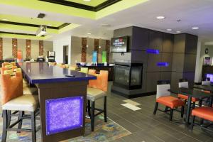 a restaurant with a bar with chairs and tables at Hampton Inn Muskogee in Muskogee