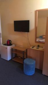 a room with a desk and a television on the wall at Петкови Лозенец in Lozenets
