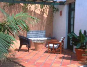 聖米格爾德阿沃納的住宿－卡薩聖米格爾酒店，庭院配有两把椅子、一张桌子和一张长凳