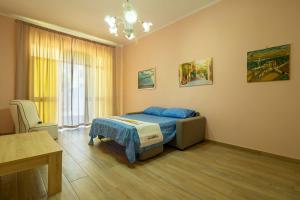 カザラーノにあるFerrari Apartmentのベッドルーム1室(ベッド1台、テーブル、窓付)