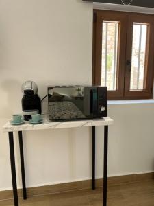 - un four micro-ondes sur une table avec deux tasses dans l'établissement El Nido del Júcar, à Alcalá del Júcar