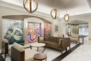 a lobby with a couch and tables and paintings at Hampton Inn Downtown / French Quarter Area in New Orleans