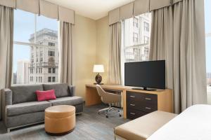 a hotel room with a bed and a couch and a television at Hampton Inn Downtown / French Quarter Area in New Orleans