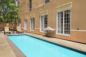 a pool with chairs and a table next to a building at Hampton Inn New Orleans/St.Charles Ave in New Orleans