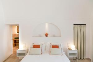 a bedroom with a white bed with white pillows at Masseria San Nicola Savelletri - B&B in Fasano +33 photos