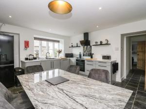 een keuken met een grote marmeren tafel en stoelen bij Ashwood Cottage in Grange Over Sands