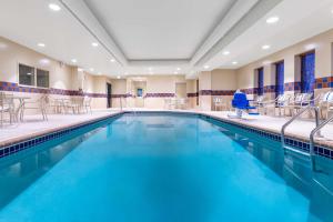 une grande piscine avec des chaises et des tables dans l'établissement Hampton Inn & Suites Minneapolis St. Paul Airport - Mall of America, à Bloomington