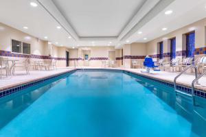a large swimming pool with chairs and tables at Hampton Inn & Suites Minneapolis St. Paul Airport - Mall of America in Bloomington