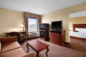 ein Hotelzimmer mit einem Bett und einem Flachbild-TV in der Unterkunft Hampton Inn Slidell in Slidell