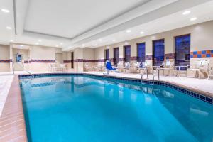 een zwembad in een hotel met stoelen en tafels bij Hampton Inn & Suites Minneapolis St. Paul Airport - Mall of America in Bloomington