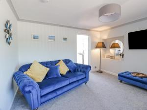 a blue couch with yellow pillows in a living room at 22 Turnberry Road in Girvan