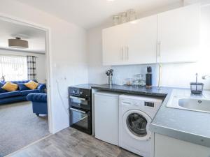 a kitchen with a washing machine and a sink at 22 Turnberry Road in Girvan
