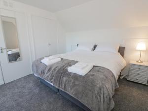 a bedroom with a bed with two towels on it at 22 Turnberry Road in Girvan