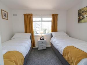 two beds in a room with a window at 22 Turnberry Road in Girvan +16 photos