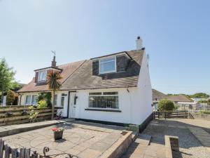 a white house with a fence and a patio at 22 Turnberry Road in Girvan