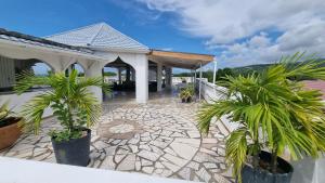 a house with palm trees in front of a patio at Little Savoy Guest House new in Runaway Bay