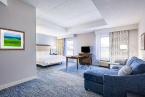 a hotel room with a bed and a desk at Hampton Inn Mount Airy in Mount Airy