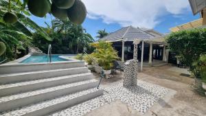 une maison avec une piscine à côté d'une maison dans l'établissement Little Savoy Guest House new, à Runaway Bay