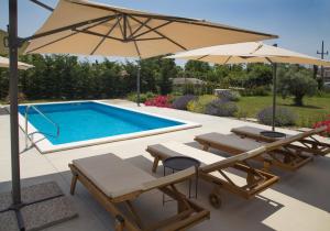 basen z dwoma krzesłami i parasolem w obiekcie Kuća Roža - Dolinci w mieście Sveti Petar u Šumi +40 zdjęć