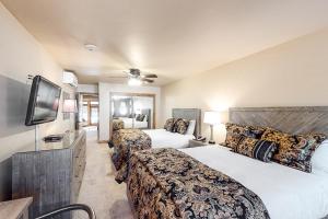 a hotel room with two beds and a flat screen tv at Lion Square Lodge East 103 in Vail