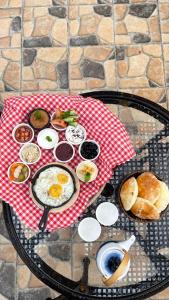 a table with a plate of breakfast food on a table at Sadeem Village & Chalet in Ash Shafa