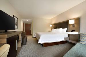 a hotel room with a bed and a flat screen tv at Hampton Inn & Suites Middletown in Middletown