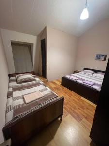 two beds are in a room with wooden floors at emily in Sarpi