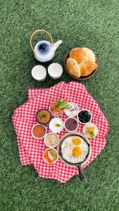 a plate of breakfast food on a red and white cloth at Sadeem Village & Chalet in Ash Shafa