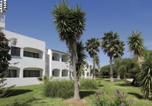 a white building with palm trees in front of it at Albergaria Dom Manuel Hotel in Porches