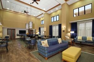 a living room with a couch and a dining room at Hampton Inn & Suites Madisonville in Madisonville